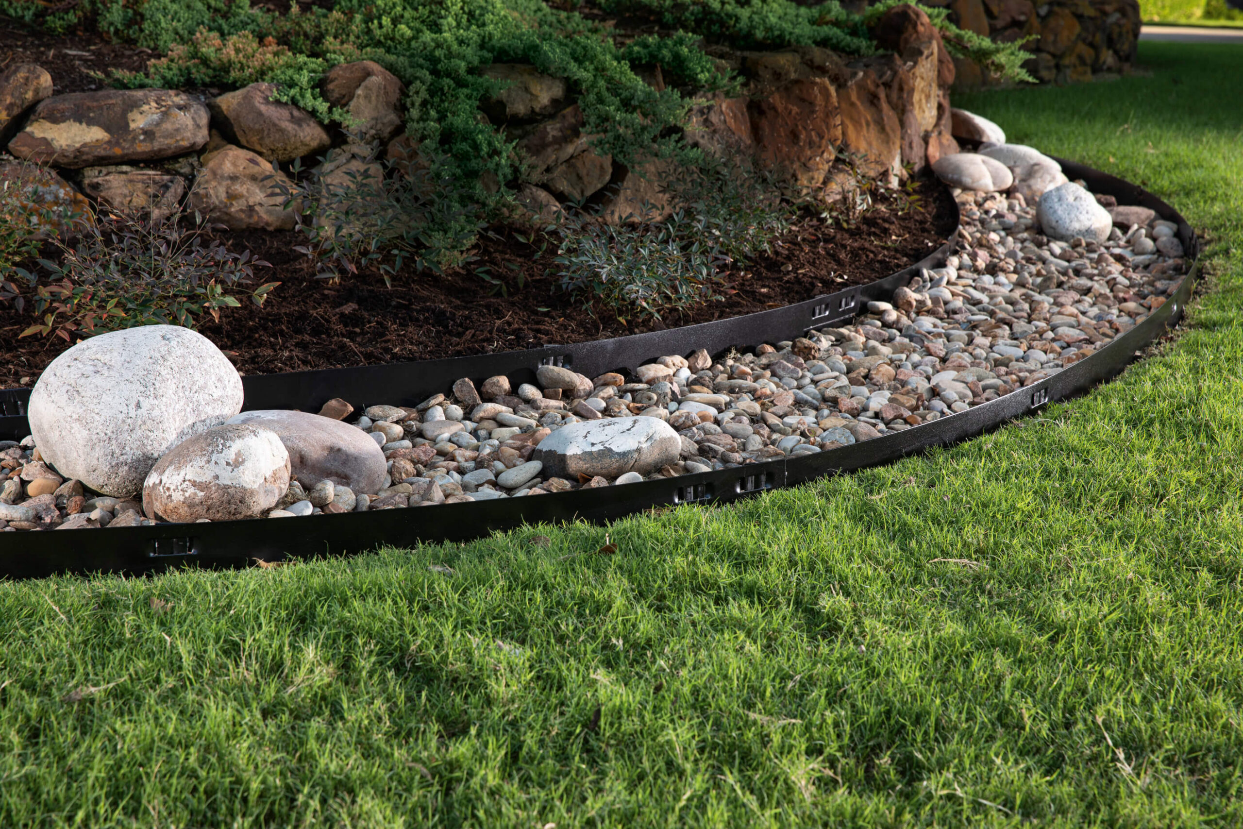 Attached-Stake Steel Edging between rocks and grass