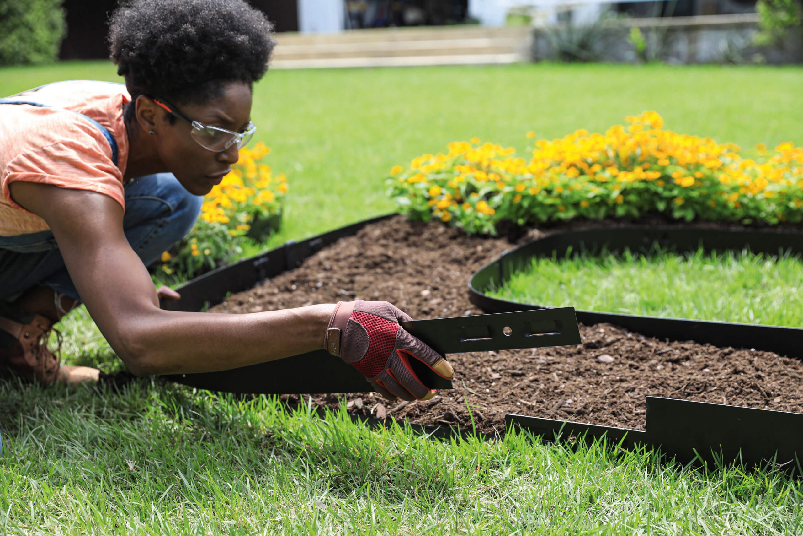 woman placing Attached-Stake Steel Edging