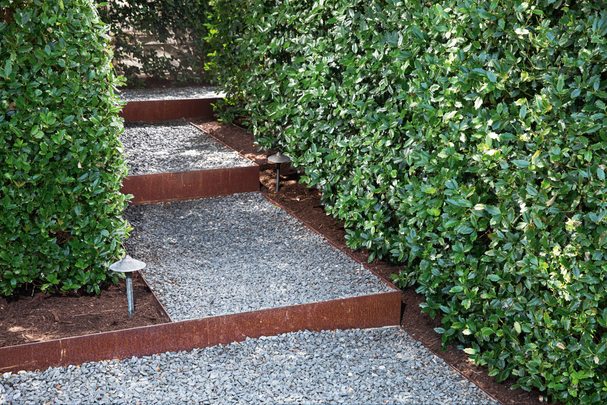 Custom Steel Edging creating stairs around rock path and hedges