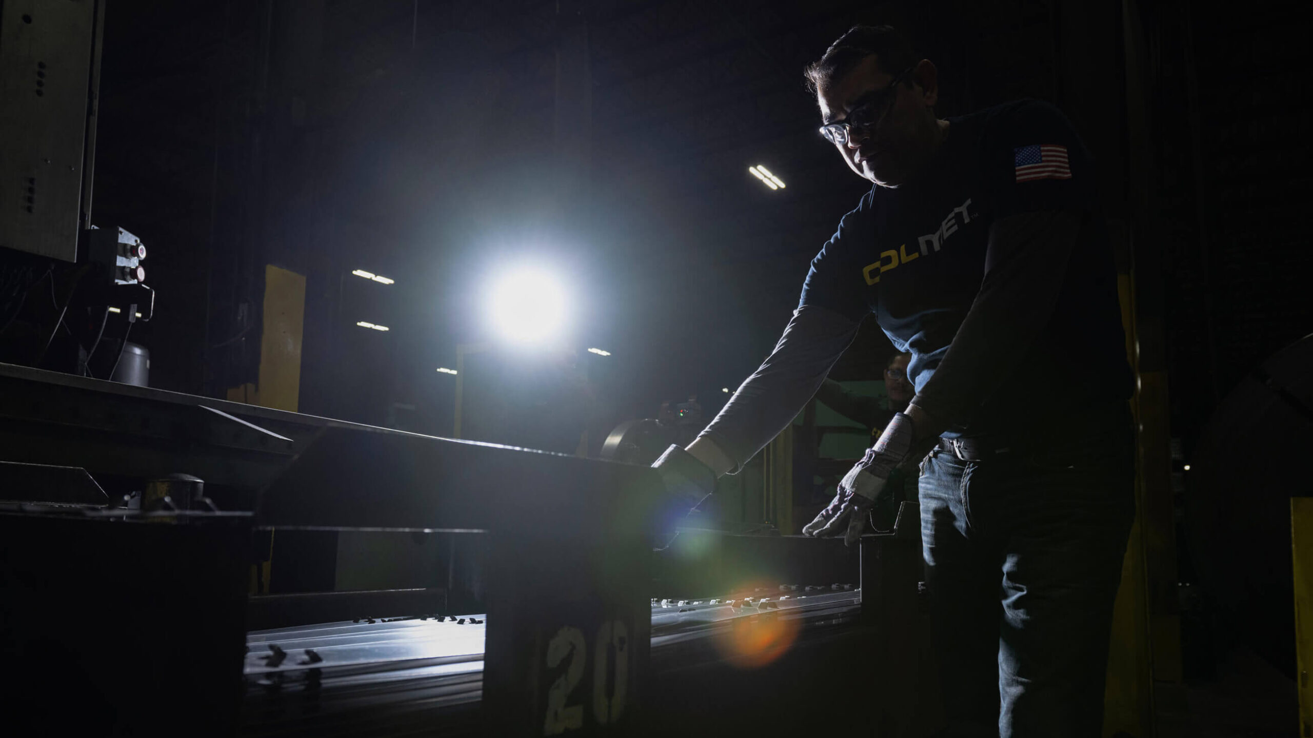 man working on machine making steel edging