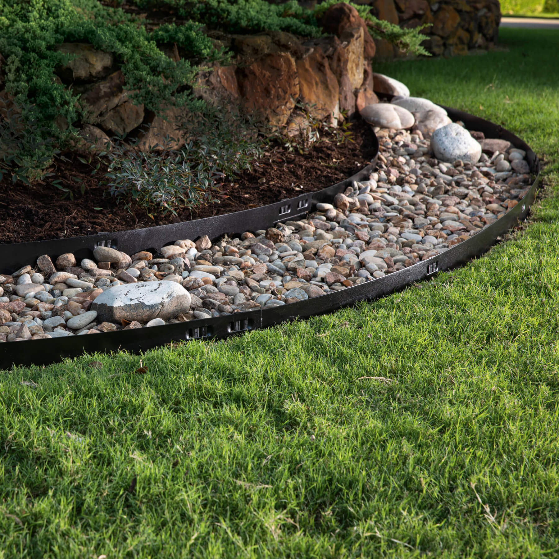 Attached-Stake Steel Edging between rocks and grass